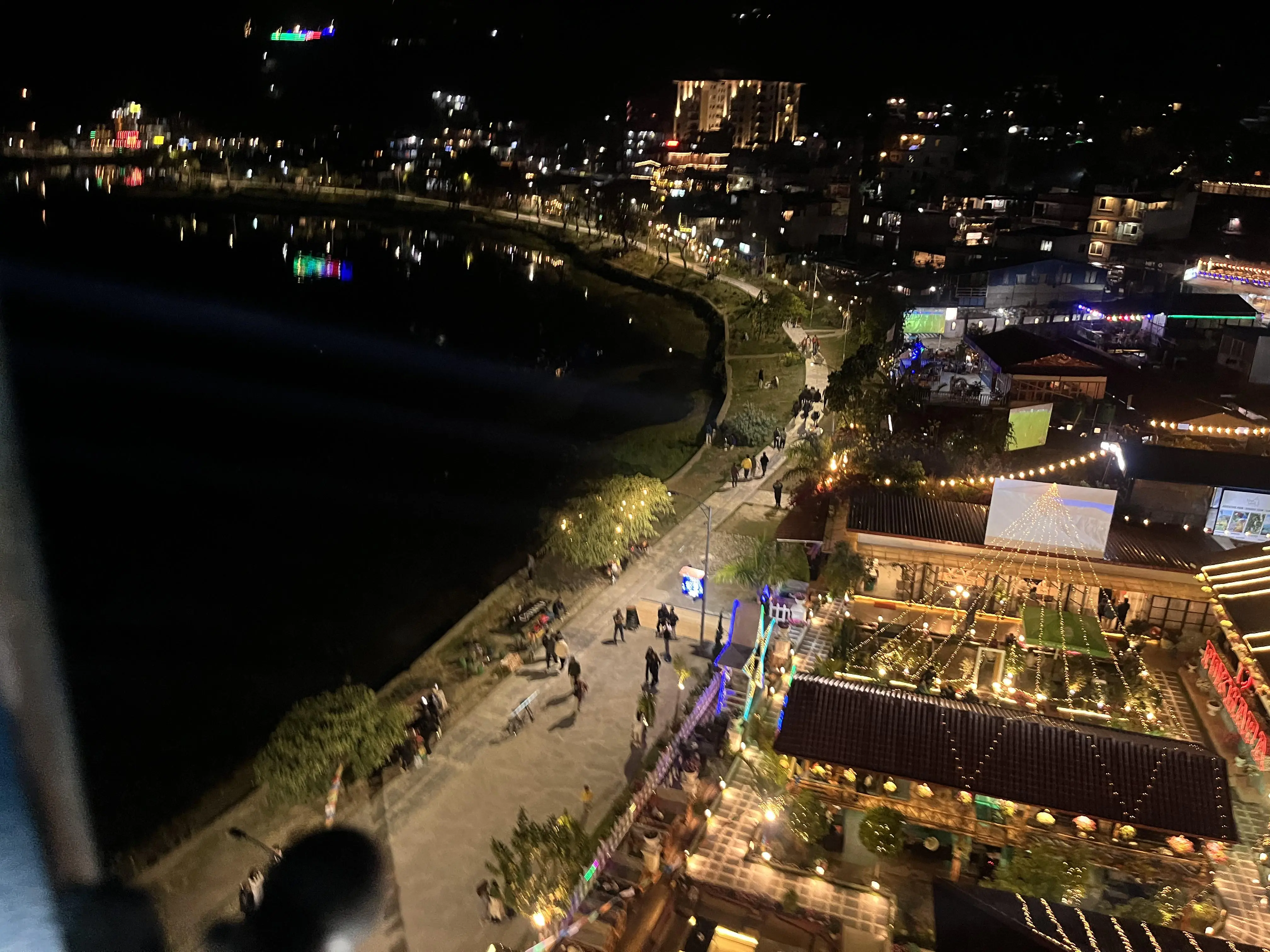 Lively street lined with cafés and shops in the evening